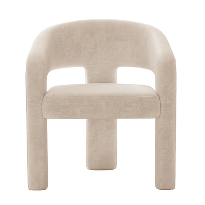 Mariah Velvet Upholstered Accent Chair - Beige features a minimalist design with a curved backrest, open cut-out detail, thick padded seat, and chunky cylindrical legs, including central support.