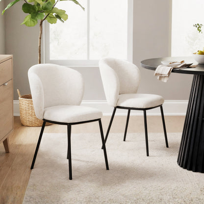 Maveri Boucle Dining Chair Set of 2 in Cream White, featuring gently curved, cushioned backrests and seats in boucle fabric, supported by slim black metal legs, in a neutral-toned dining nook.
