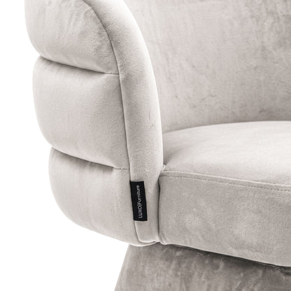 Close-up of the grey swivel dining chair showing its smooth fabric texture and stitched channel-back design.