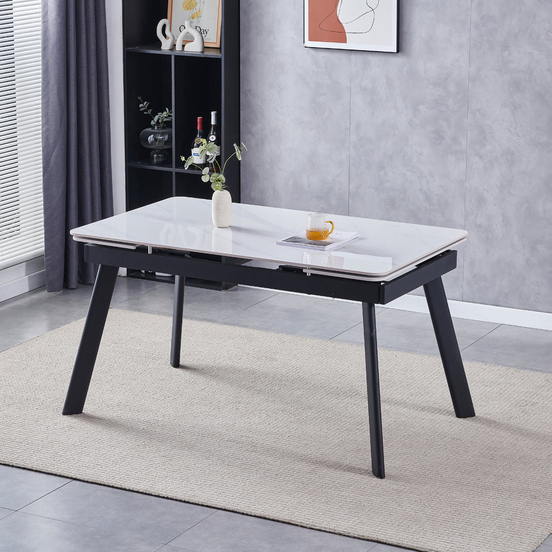 Rheed 197cm Extendable Ceramic Porcelain Dining Table White with glossy marble-look top, black metal legs, styled with a ceramic vase, book, and glass mug on a woven rug.