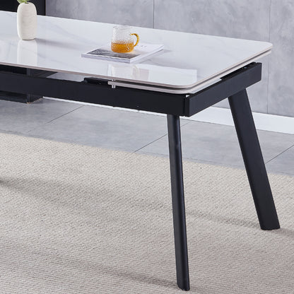 Rheed 197cm Extendable Ceramic Porcelain Dining Table White with a sleek white marble-look top and sturdy black splayed metal legs, adorned with a small vase and a glass mug on an open magazine.