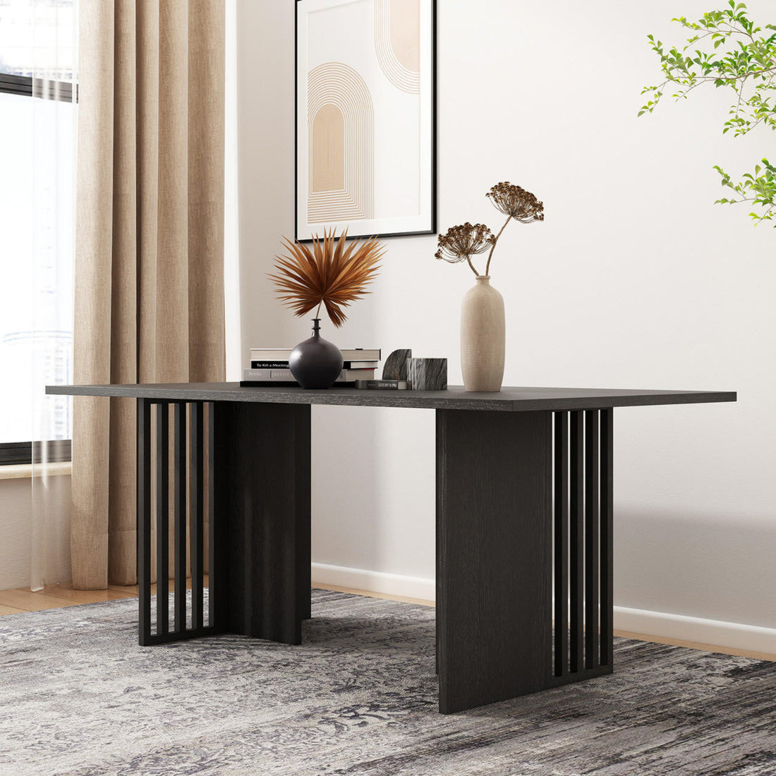 Rowley 180cm Dining Table Black in a modern setting, featuring a sleek black tabletop with vertical slat legs, styled with decorative vases, books, and a geometric block against a minimalist backdrop.