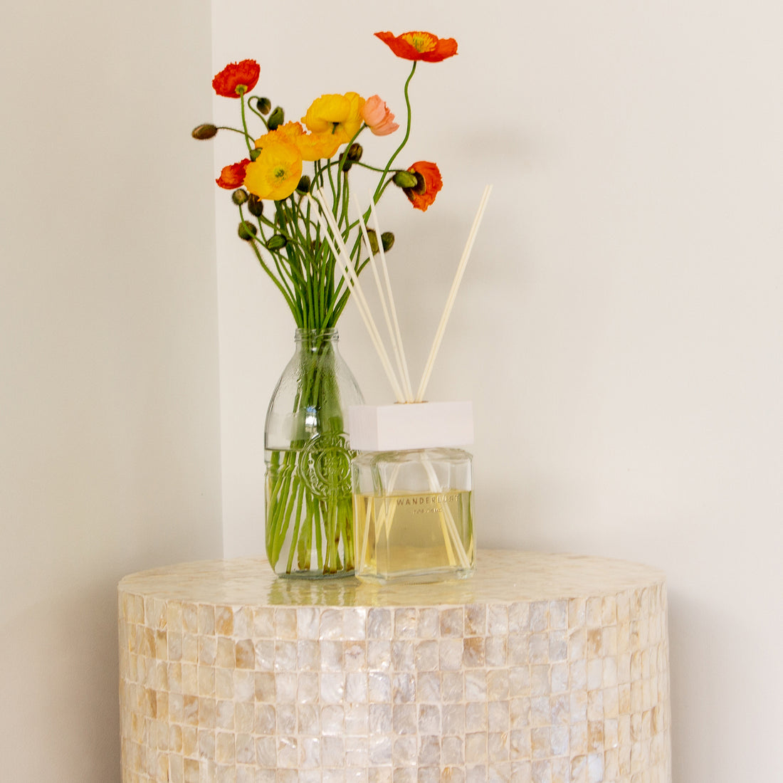 Tiffany 48cm Mother of Pearl Inlay Side Table Cream is elegantly displayed in a setting adorned with a vase of flowers, emphasizing its intricate mother-of-pearl design and refined craftsmanship.