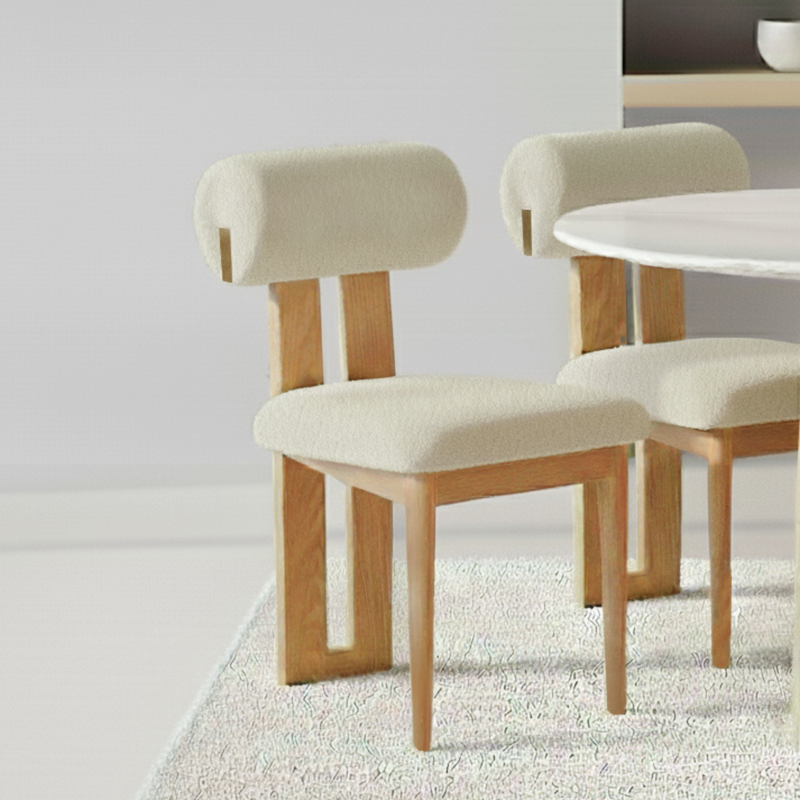 Wylie Boucle Oak Dining Chair Set of 2 in Beige, featuring light wood frames and cream upholstered seats, with a round white tabletop and textured rug in a minimalist dining nook.