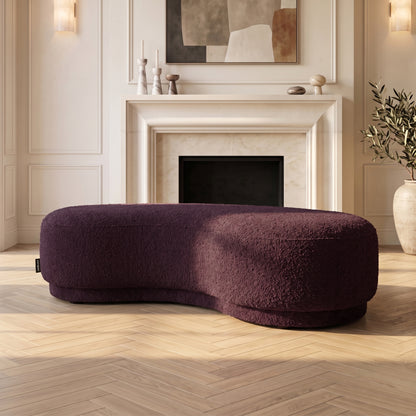 Curved plum upholstered bench seat in an elegant living room setting