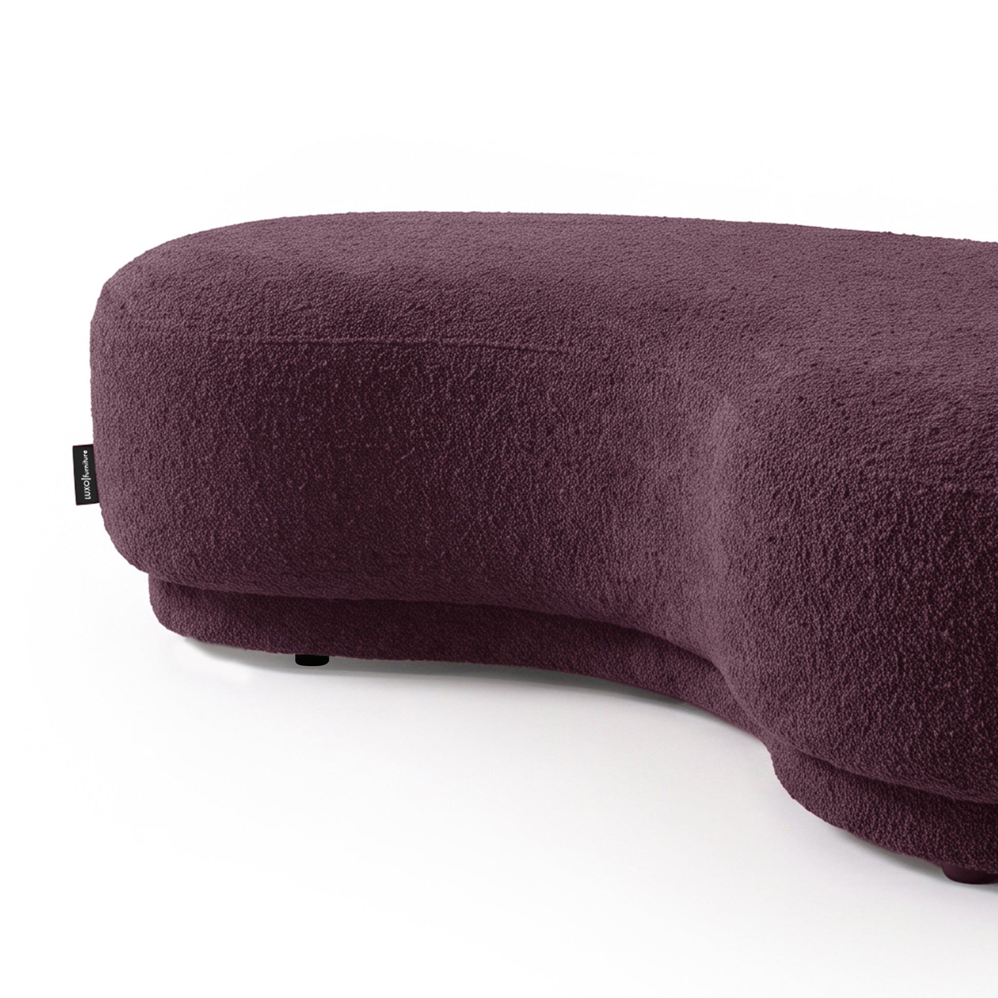 Kidney-bean shaped upholstered seating in rich plum color on a white background