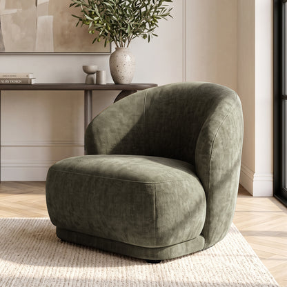 Moss green upholstered accent chair styled in a modern living room