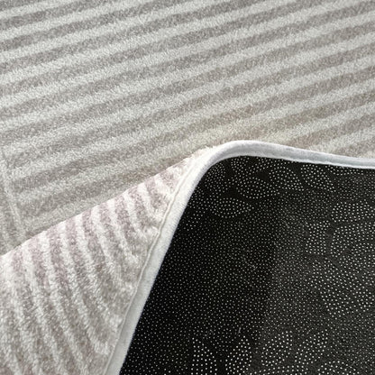 Colton 2 Seater Fabric Sofa with Rug - Cream White close-up showing a fluffy, striped white rug with a flipped corner revealing black non-slip backing, displayed on light grey carpet.