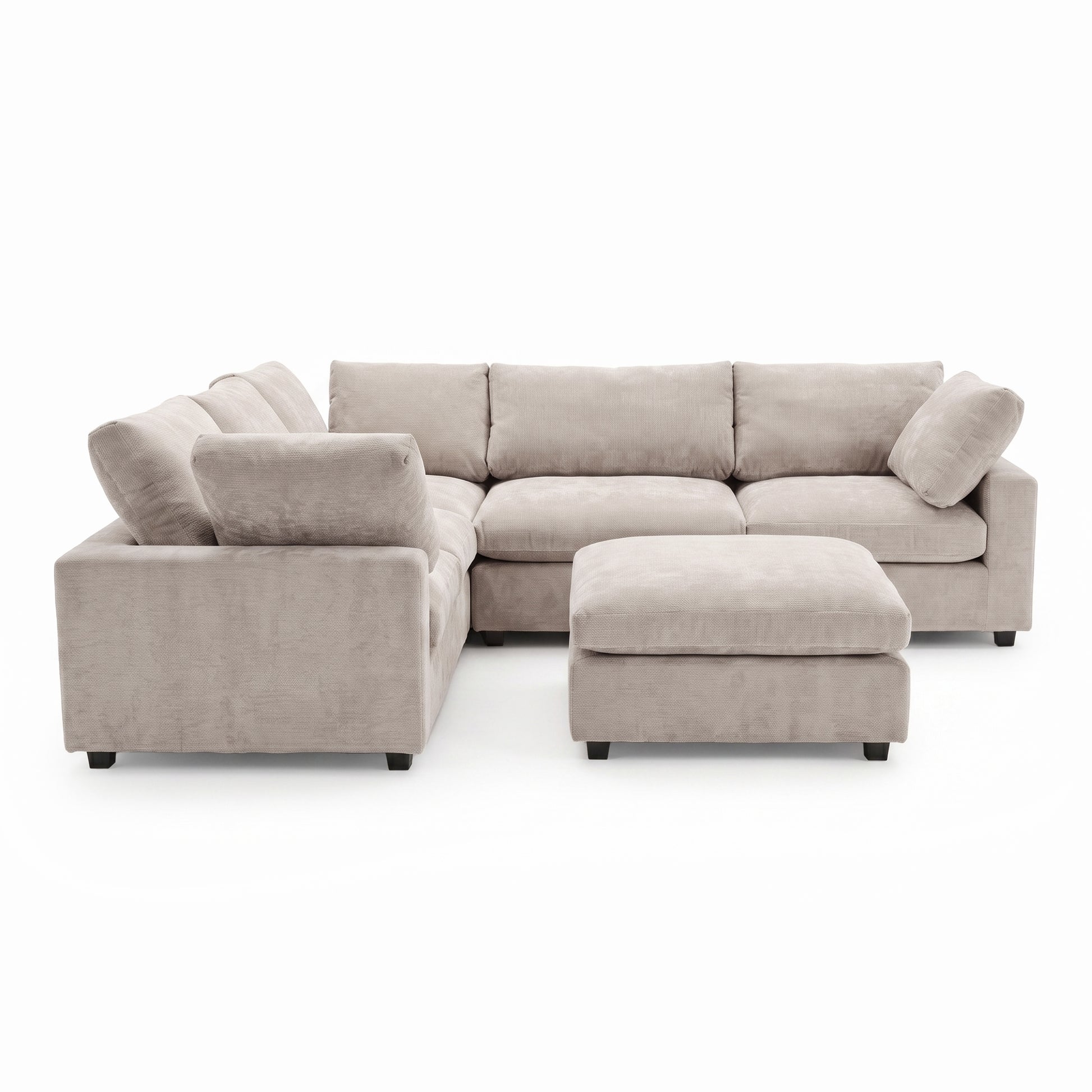 A modular corner sofa in soft griege, plush fabric, featuring deep seats, comfortable back cushions, and a matching square ottoman positioned in front.