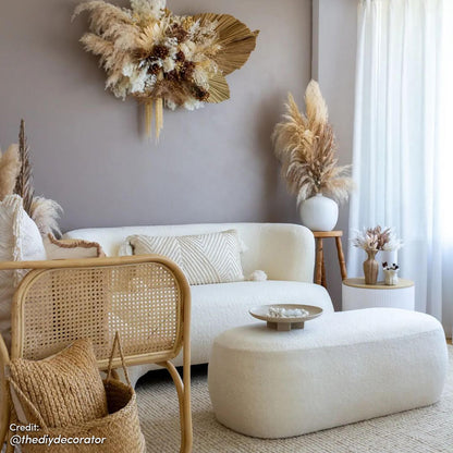 Jamie 110cm Boucle Fabric Ottoman in Cream White featured centrally, topped with a decorative bowl, matches a boucle sofa, set in a modern boho nook with dried floral accents and natural textures.