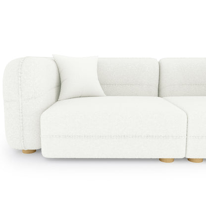The image features the Kaelyn 3 Seater Modular Boucle Sofa with Pillows in Cream, showcasing its left armrest, seat module, matching throw pillow, and low, round wooden legs.