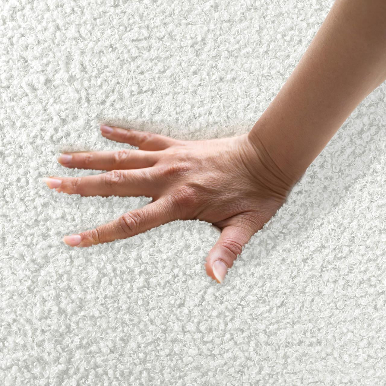 Hand pressing on the plush, loop-textured surface of the Massie 2-Seater Boucle Sofa in Cream White, highlighting its soft, cushiony feel, embodying luxurious comfort and cozy appeal.