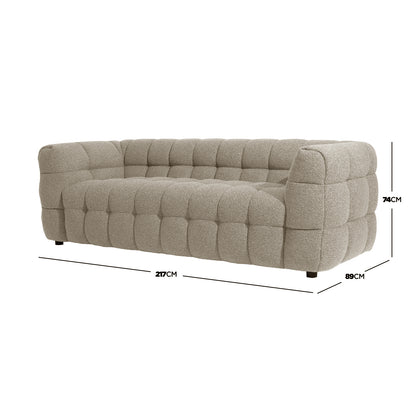 Norah 3 Seater Boucle Sofa in Warm Beige features a low-profile, plush, deeply tufted surface with boucle fabric. Dimensions: 217cm width, 89cm depth, 74cm height, offering a modern, cushioned look.