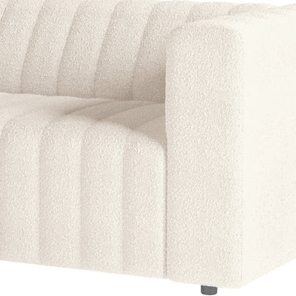 Close-up of the Parisa 3 Seater Tufted Boucle Sofa in Cream White, showcasing its textured bouclé fabric and vertical channel tufting with a glimpse of a small round leg at the bottom.