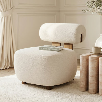 Renley Boucle Armless Accent Chair in Cream White, featuring plush boucle texture and modern organic lines, accompanied by a matching ottoman on a cream rug with a side table and decor accents.