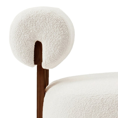 Renley Boucle Armless Accent Chair features a cream nubby bouclé fabric on a plush armrest and seat, supported by a dark-stained wood frame visible behind the arm pad.