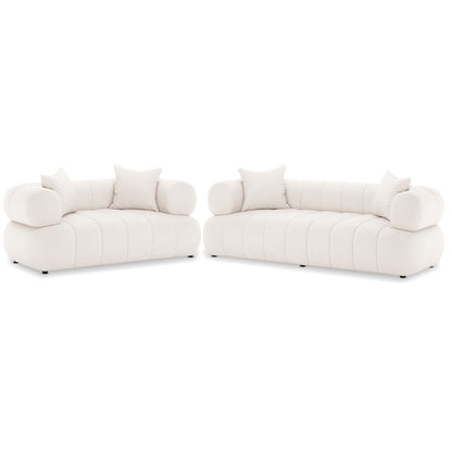 Samira 5 Seater Velvet Sofa Set in Cream, featuring two matching off-white upholstered sofas with low, channel-tufted bases, rounded bolster armrests, and square back-rest pillows, exuding elegance and comfort.