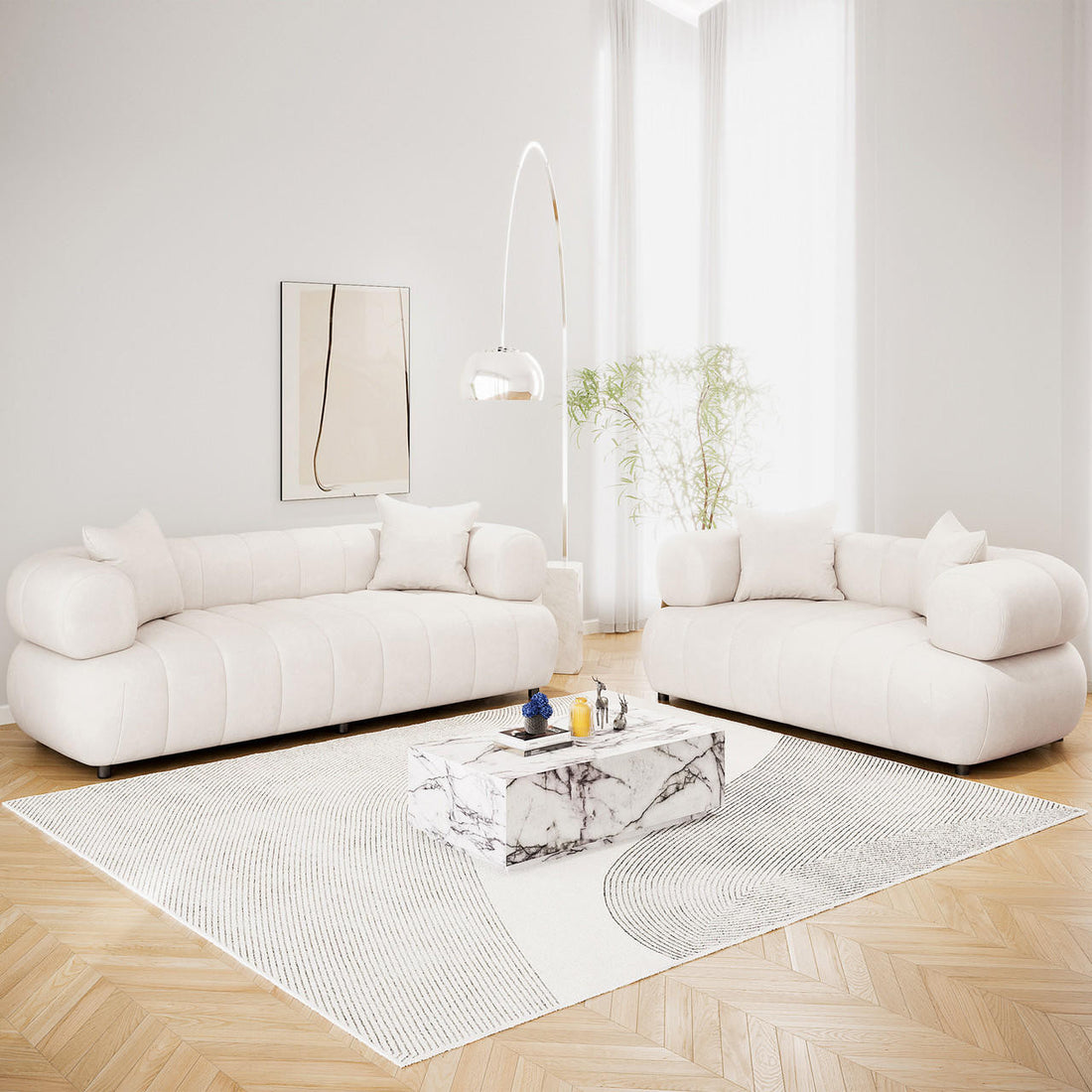 Samira 5 Seater Velvet Sofa Set in Cream, featuring low-profile sofas with cylindrical bolster arms, matching throw pillows, and plush cream velvet upholstery, elegantly arranged in a bright, minimalist living room.