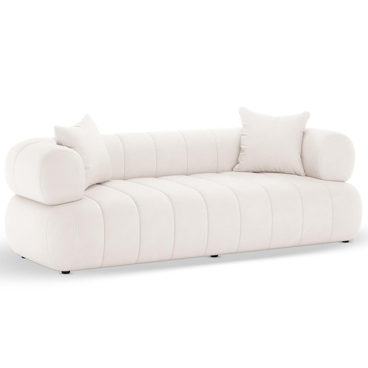 Samira 5 Seater Velvet Sofa Set in Cream, featuring a low-profile design with vertical channel-tufting, cylindrical bolster arms, and matching throw pillows, exuding elegance and comfort in velvet upholstery.