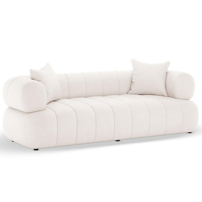 Samira 5 Seater Velvet Sofa Set in Cream, featuring a low-profile design with vertical channel-tufting, cylindrical bolster arms, and matching throw pillows, exuding elegance and comfort in velvet upholstery.