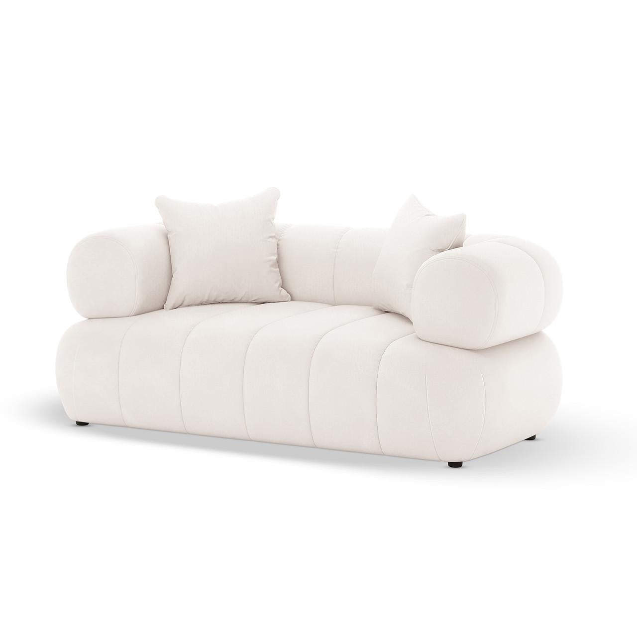 Samira 5 Seater Velvet Sofa Set in Cream features a modern, low-profile design with channel-tufted base, cylindrical bolster arms, and matching throw pillows, offering an elegant and plush seating experience.