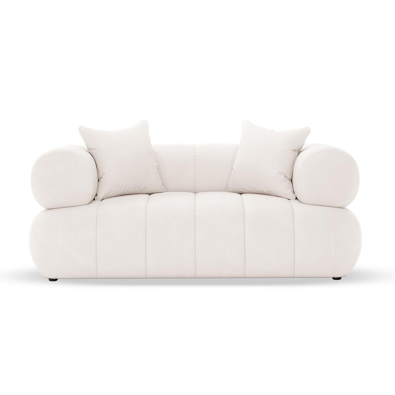 Samira 2 Seater Velvet Lounge in Cream features a modern loveseat with all-white upholstery, two square throw pillows, and cylindrical bolster cushions on the arms, offering a blend of luxury and comfort.