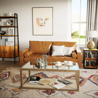 Sollia 3 Seater PU Leather Sofa - Tan Brown in a cozy setting, surrounded by books and a cup, showcasing its sleek design and luxurious comfort in a stylish indoor space.