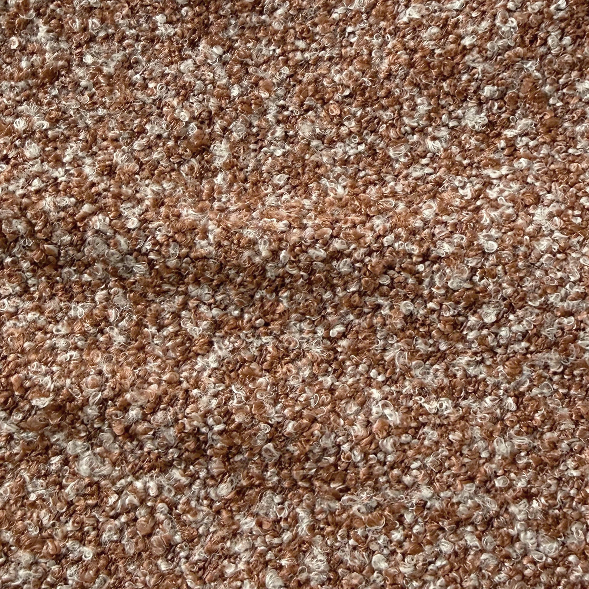 Close-up of the Sornel Boucle Upholstered Accent Chair in Coral, showcasing its textured boucle fabric with looped, curly fibers, highlighting the chair's tactile and high-density comfort design.