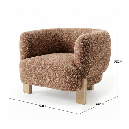 Sornel Boucle Upholstered Accent Chair in Coral featuring a textured brown bouclé fabric, low sculpted back, rounded armrests, and chunky block legs, highlighting its organic curves and generous footprint.