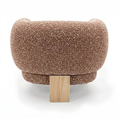 Sornel Boucle Upholstered Accent Chair in Coral, showcasing its rounded, low-profile design with brown, speckled boucle fabric and a central blocky wooden leg, against a white background.