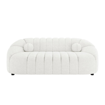 Trina 3 Seater Boucle Sofa with Pillows in Cream White features a modern design with curved arms, vertical channel tufting, and includes matching round bolster pillows, all on discreet black feet.