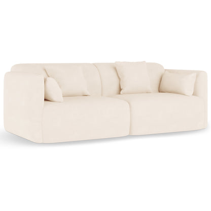 Vestalia 4 Seater Velvet Sofa Set in Cream White, featuring a modern, curved design with two adjoining modules, upholstered in cream velvet, and styled with matching throw pillows for elegance and comfort.