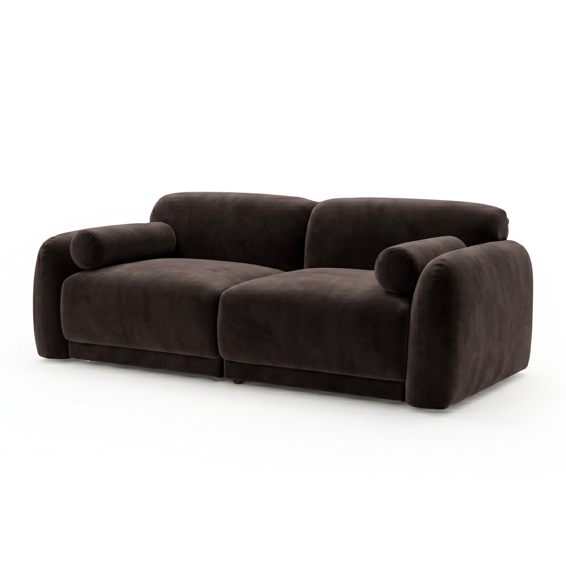 Dark brown velvet sofa with rounded armrests and cylindrical bolster pillows on white background