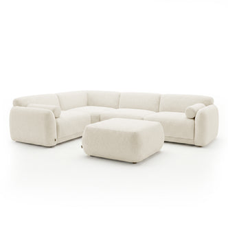 Cream sectional sofa with matching ottoman on a white background