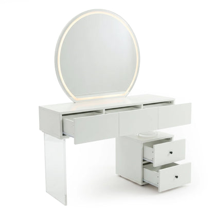 A modern white dressing table featuring a large, round, illuminated mirror, a wide table with three shallow drawers, and a side cabinet with two additional drawers, all supported by a transparent acrylic leg.