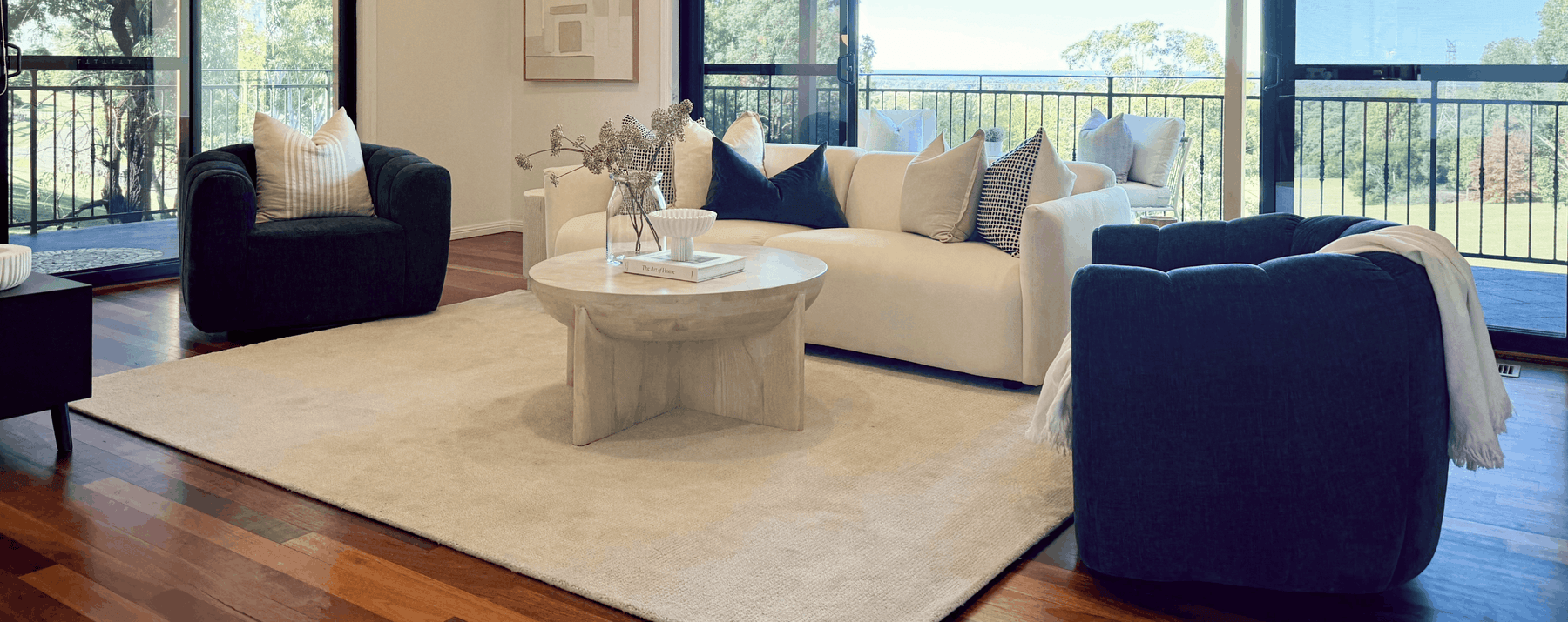 Living room with white sofa, navy armchairs and round coffee table