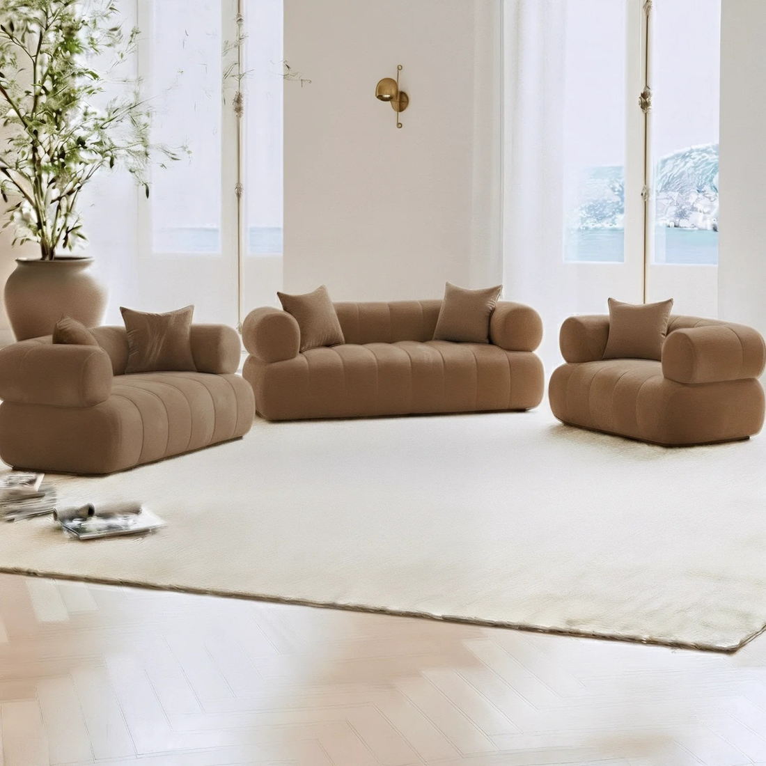 Samira 6 Seater Velvet Sofa Set in Camel Brown, featuring three low-profile, rounded-edge sofas with matching pillows, set in a bright minimalist living room with large windows and elegant decor.