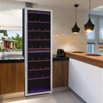 G180D 180 Bottle Dual Zone Wine Fridge in Black integrated into a kitchen island, featuring purple/blue LED lighting inside, horizontal wine bottle shelving, and a digital temperature readout.