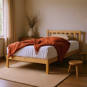Drusa Single Solid Pine Wooden Bed Frame in Natural, featuring a light-wood construction with a minimalist design, paired with a rust throw blanket and beige pillow, placed on a natural-fiber rug.