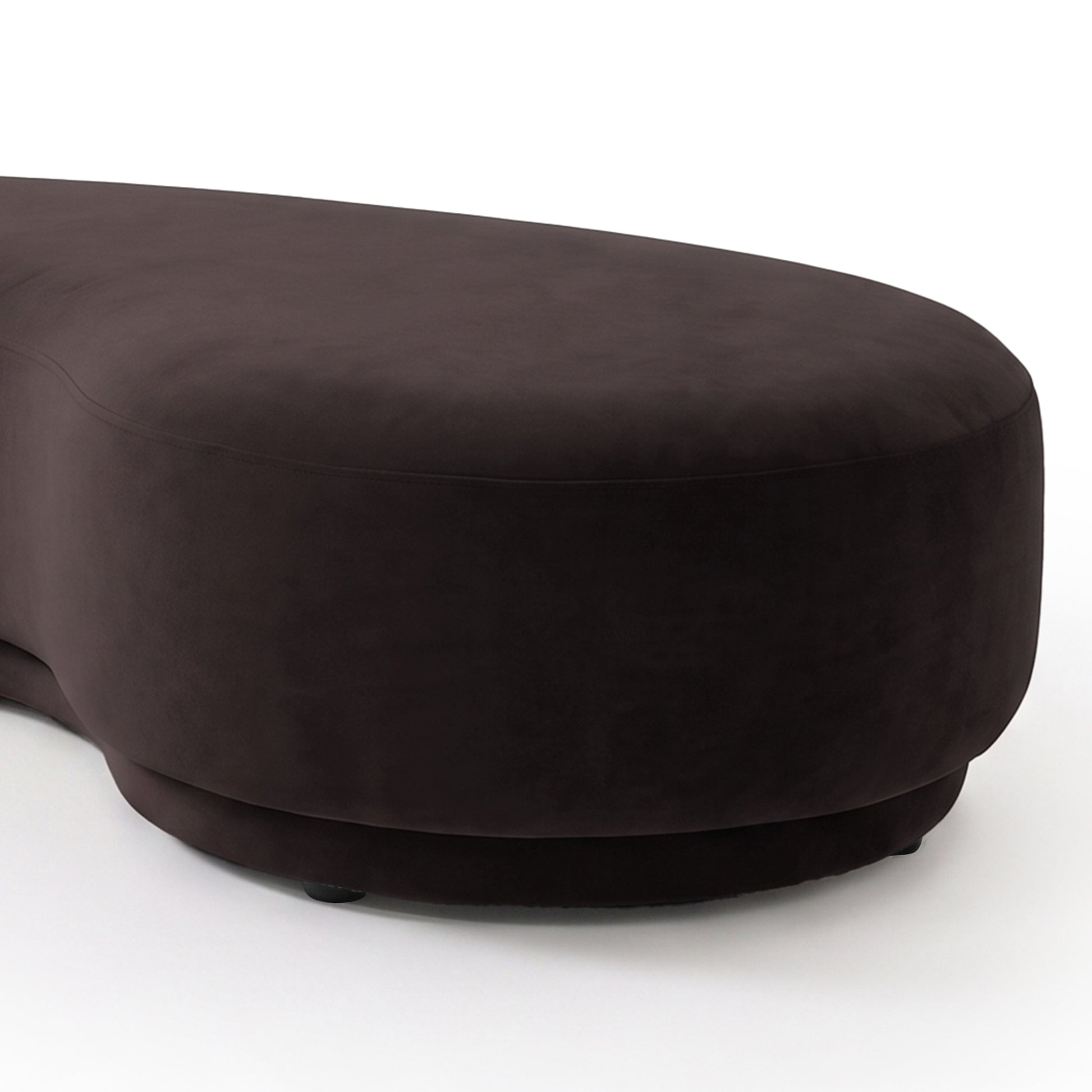 Close-up partial view of a plum curved upholstered product on a light background