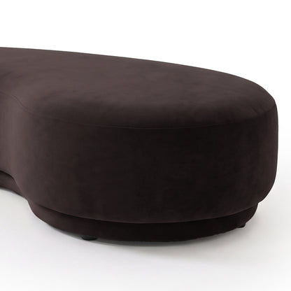 Close-up partial view of a plum curved upholstered product on a light background