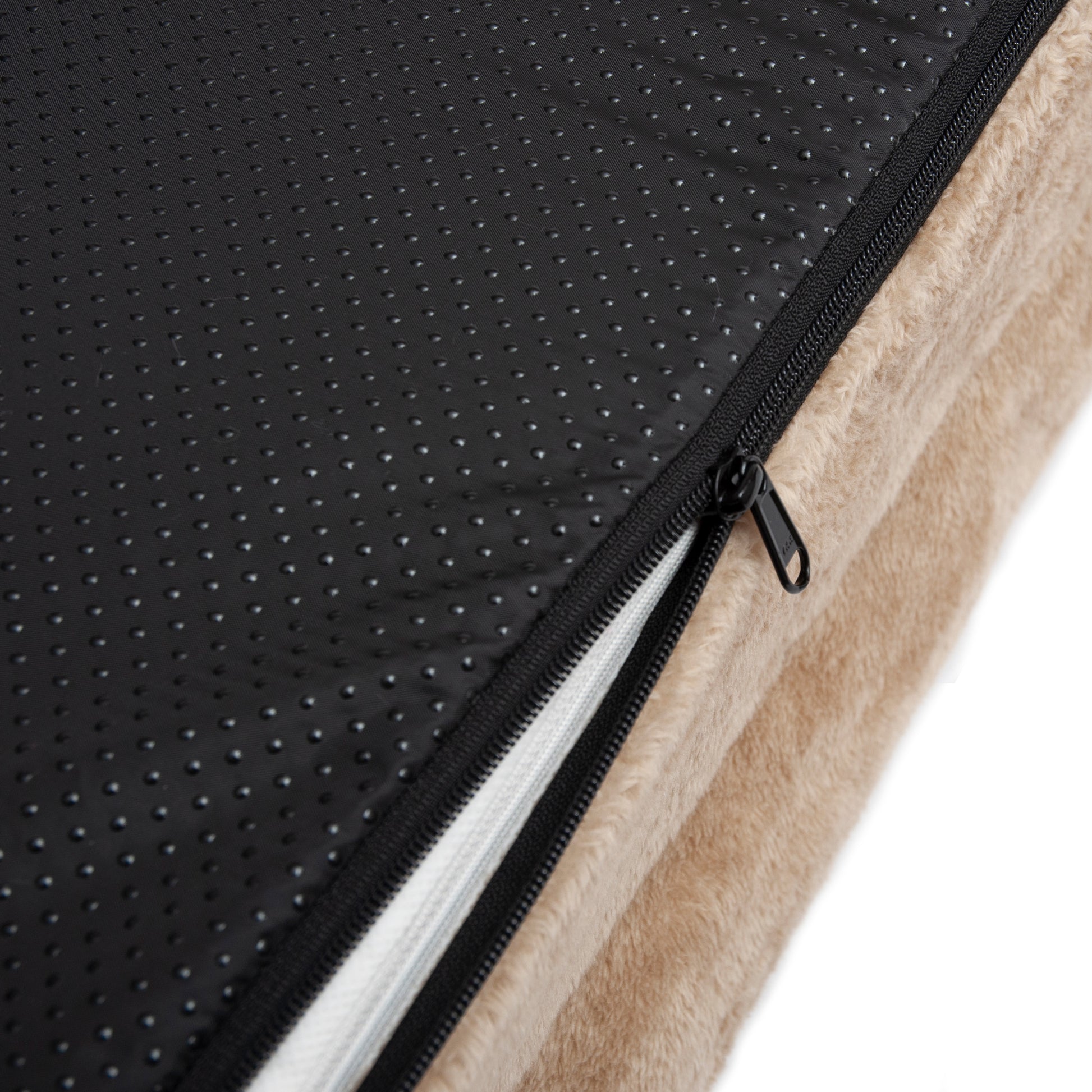 Close-up of beige and black fabric with zipper revealing inner padding