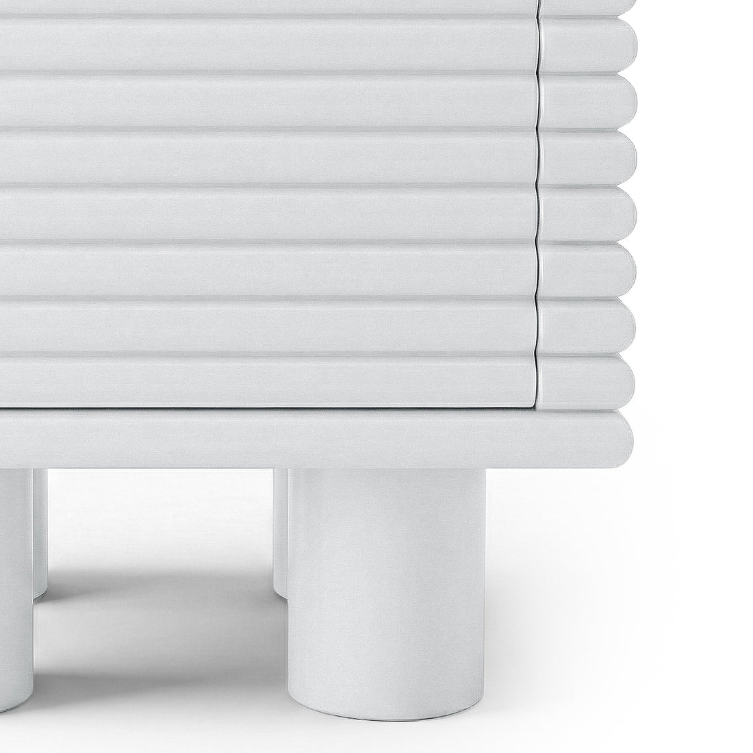 Close-up of the lower half of a ribbed white side table on white background