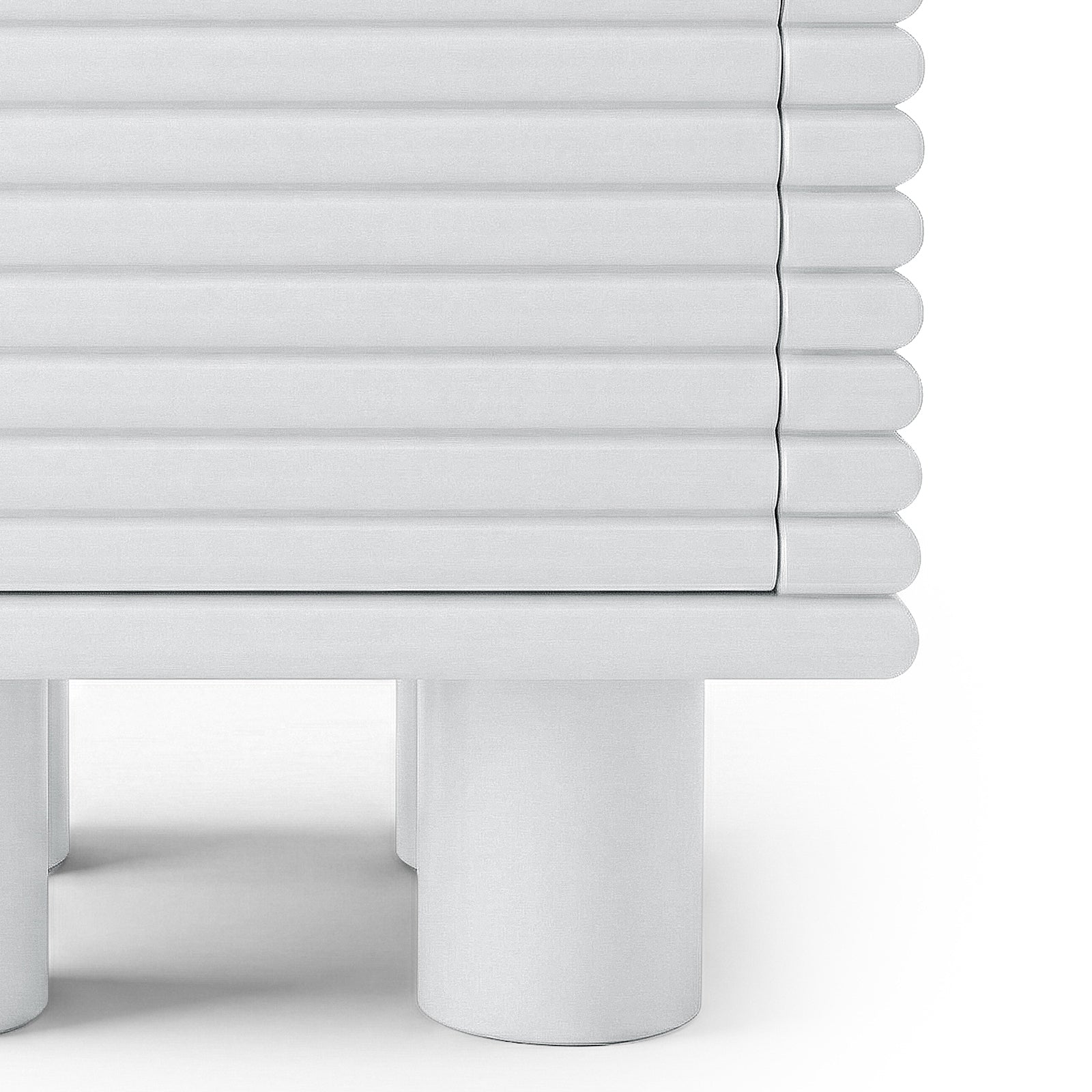 Close-up of the lower half of a ribbed white side table on white background