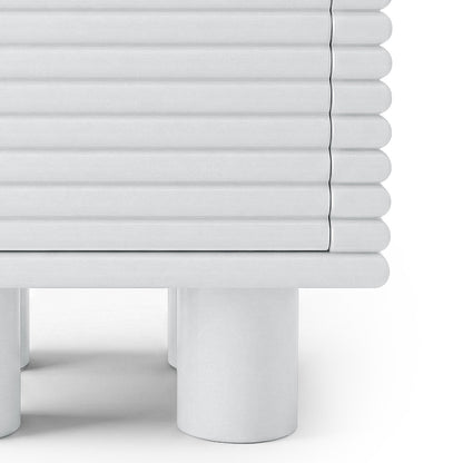 Close-up of the lower half of a ribbed white side table on white background