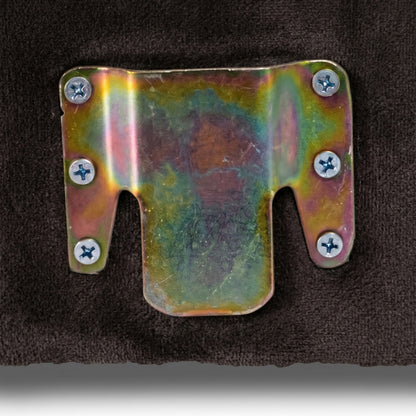 Close-up of multi-colored metal bracket fastened to brown fabric surface