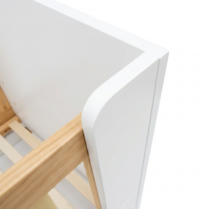 Close-up of furniture corner showing wood and white panel joinery