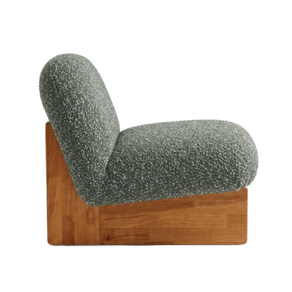 Side profile of green accent chair on white background