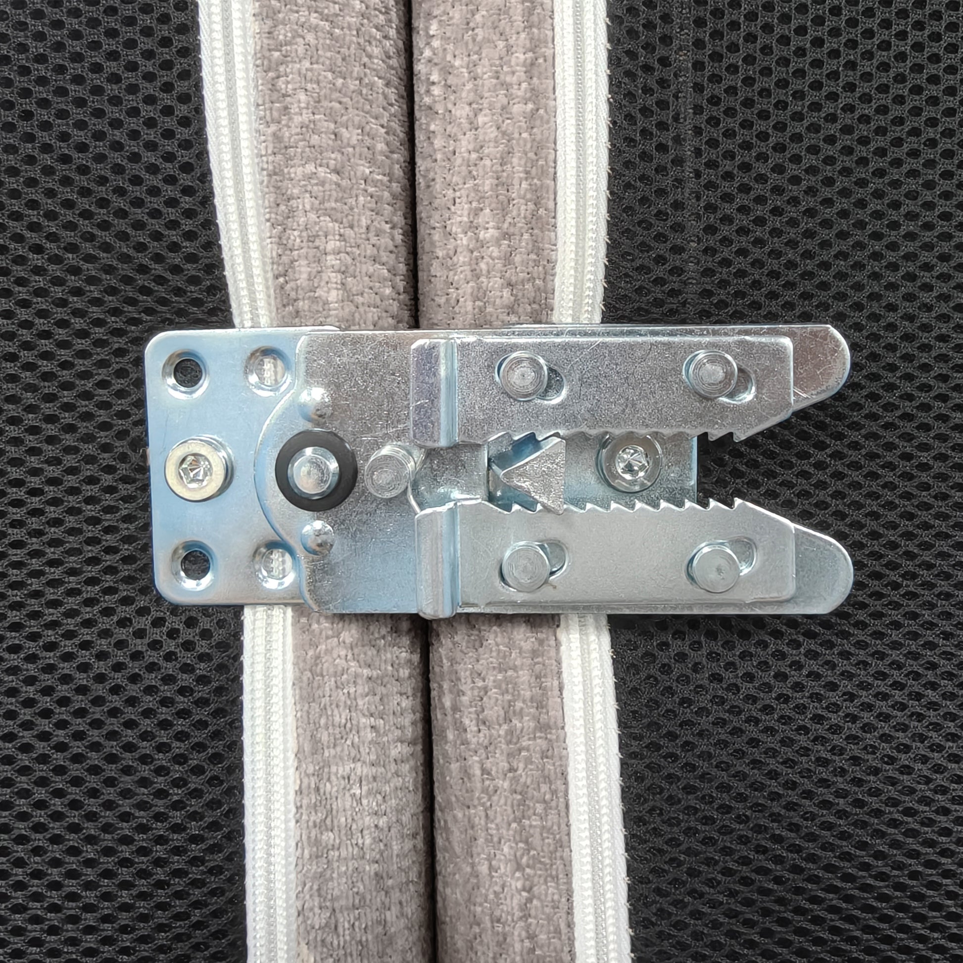 Close-up of metal latch hardware attached to padded fabric panels