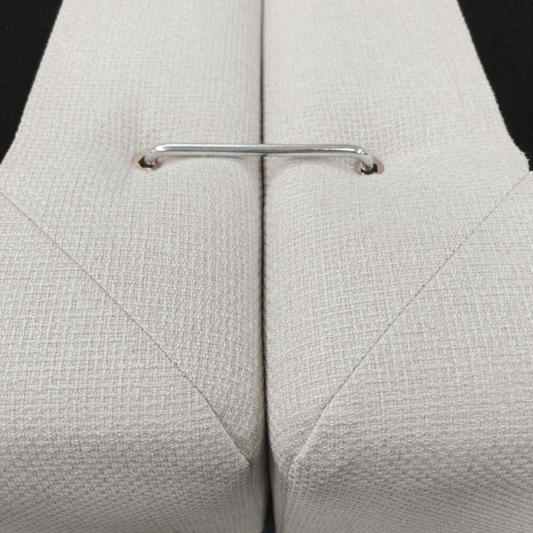 Close-up of two upholstered sofa sections joined by a metal connector.